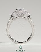 Kynora CJ 2ct oval claw trilogy engagement ring with pear side stones and pave band, featuring sparkling diamond accents.