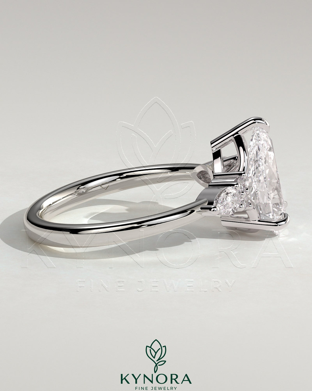 Kynora CJ 2ct pear claw solitaire engagement ring with pear accents and round shoulder stones, elegant three stone design.