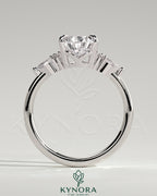 Kynora CJ 2ct pear claw solitaire engagement ring with pear-shaped accents and round shoulder stones, elegant three-stone design.