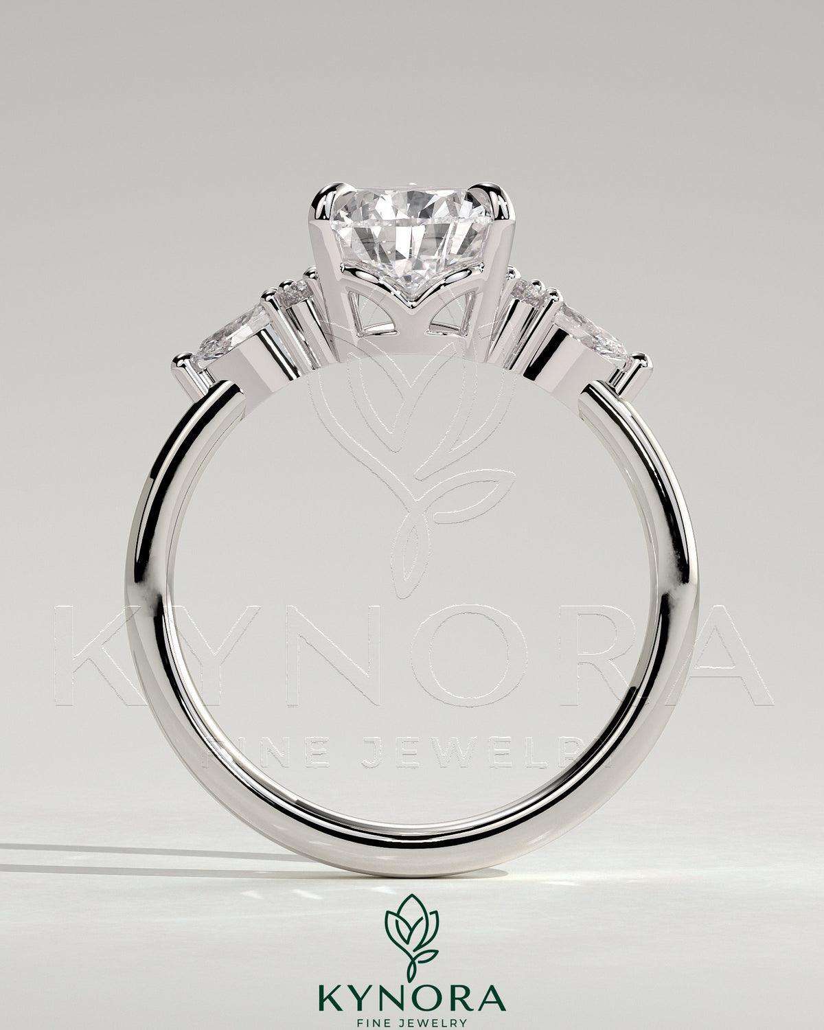 Kynora CJ 2ct pear claw solitaire engagement ring with pear-shaped accents and round shoulder stones, elegant three-stone design.