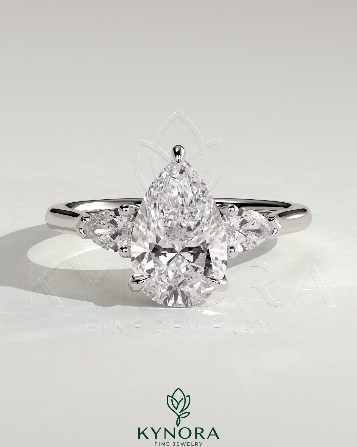 Kynora CJ 2ct pear claw trilogy engagement ring with side stones and cathedral setting, showcasing sparkling diamond design. Main image
