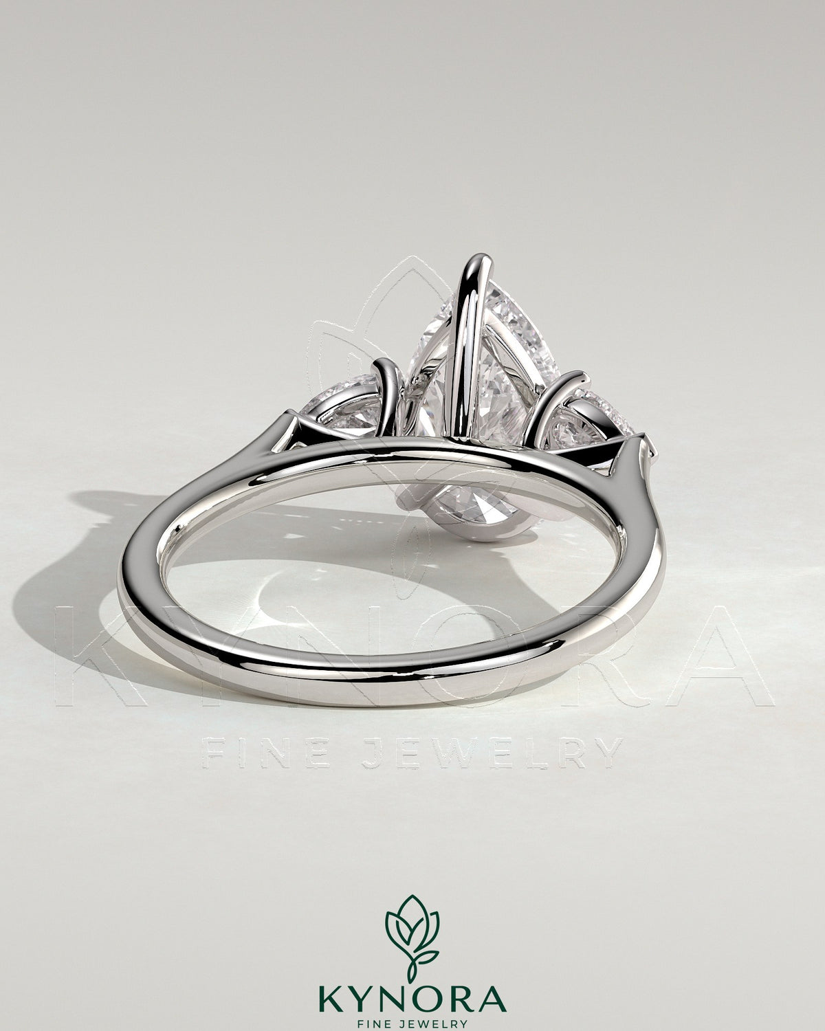 Kynora CJ 2ct pear-shaped trilogy engagement ring with side stones and cathedral setting, featuring a sparkling pear center stone.