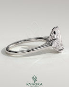 Kynora CJ 2ct pear claw trilogy engagement ring with side stones and cathedral setting, featuring a central pear-shaped diamond.