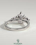 Kynora CJ 2ct pear-shaped trilogy engagement ring with side stones, pave band, and cathedral high setting.