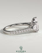 Kynora CJ 2ct pear-shaped diamond trilogy engagement ring with side stones, pave band, and cathedral high setting.