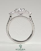 Kynora CJ three-stone engagement ring with 2ct pear-shaped center stone, side stones, pave band, and cathedral setting.