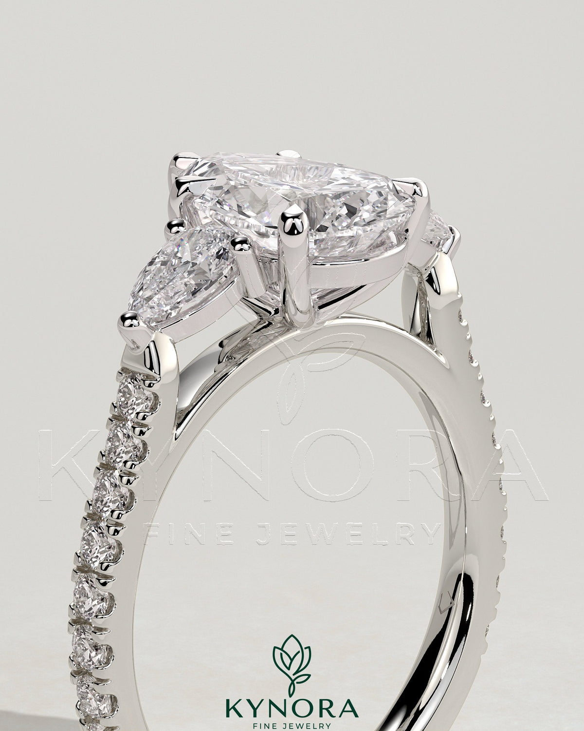 Kynora CJ 2ct pear-shaped engagement ring with trilogy design, side stones, pave band, and cathedral high setting.