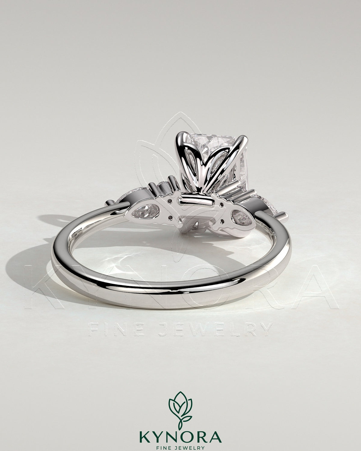 Kynora CJ 2ct radiant claw solitaire engagement ring featuring pear-shaped accents and round shoulder stones.