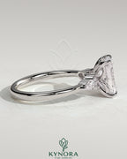 Kynora CJ 2ct radiant claw solitaire engagement ring with pear-shaped accents and round shoulder stones.
