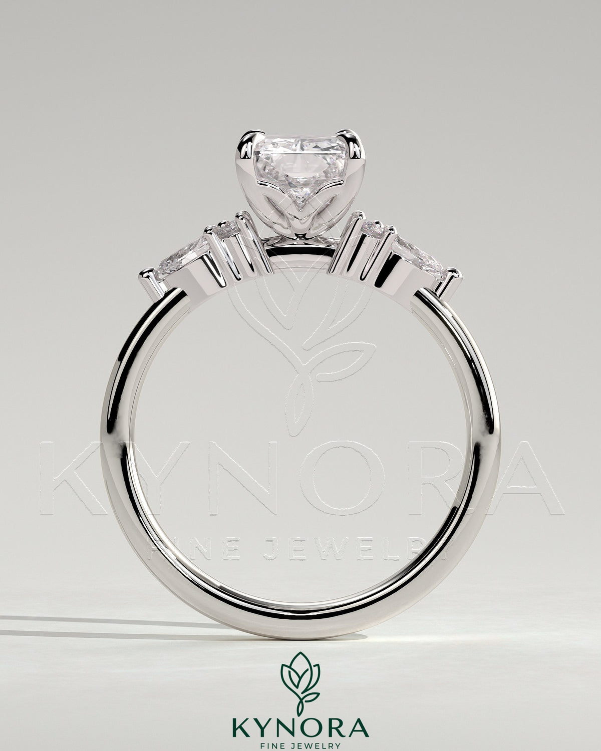 Kynora CJ 2ct radiant claw solitaire engagement ring with pear accents and round shoulder stones, elegant three stone design.