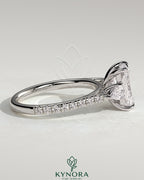 Kynora CJ 2ct radiant claw trilogy engagement ring with pear side stones and pave band, featuring a sparkling three-stone design.