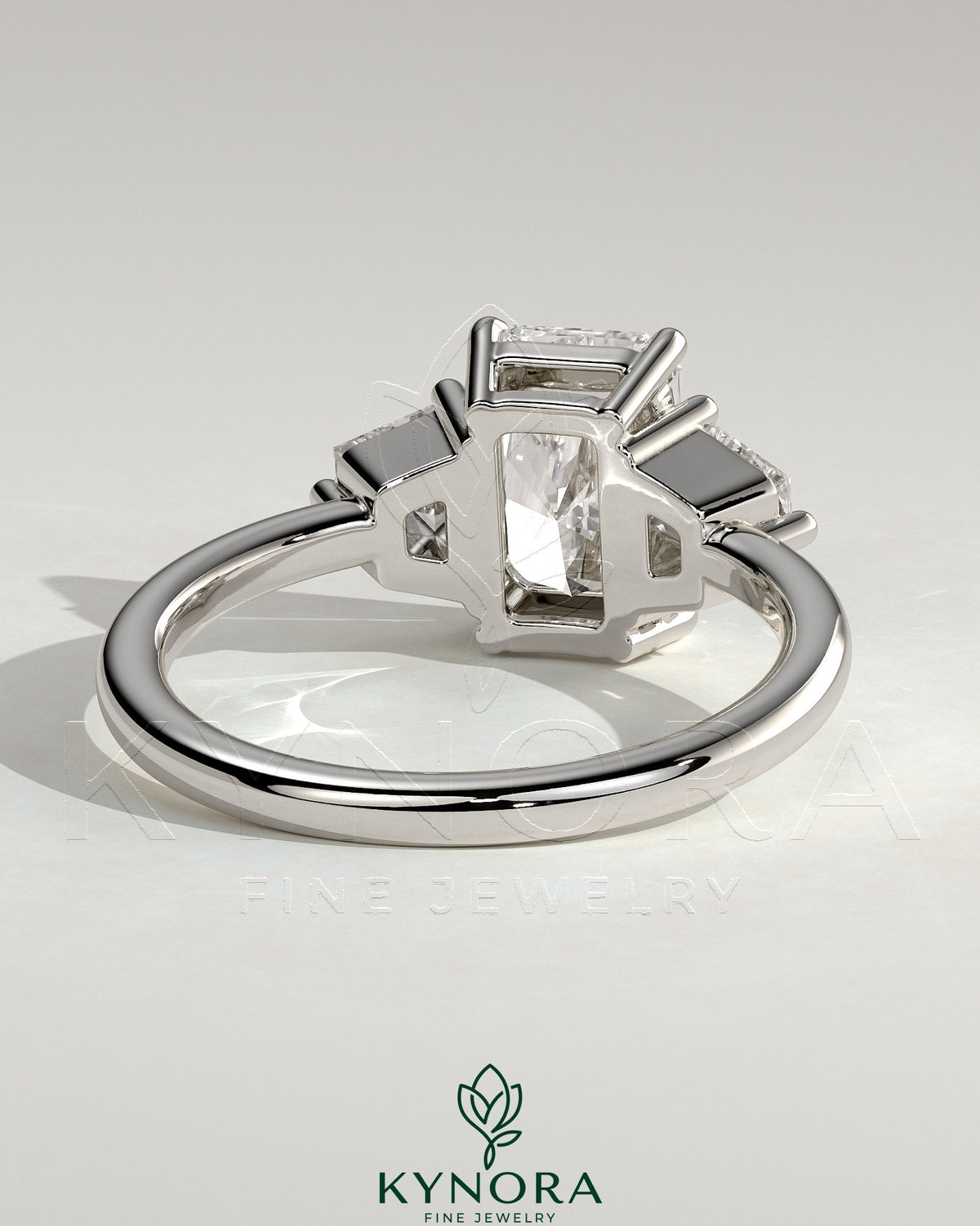 Kynora CJ 2ct radiant claw trilogy engagement ring with trapezoid side stones in a low setting, showcasing sparkling diamond design.