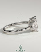 Kynora CJ 2ct radiant claw trilogy engagement ring with trapezoid side stones and low setting, showcasing elegant diamond craftsmanship.
