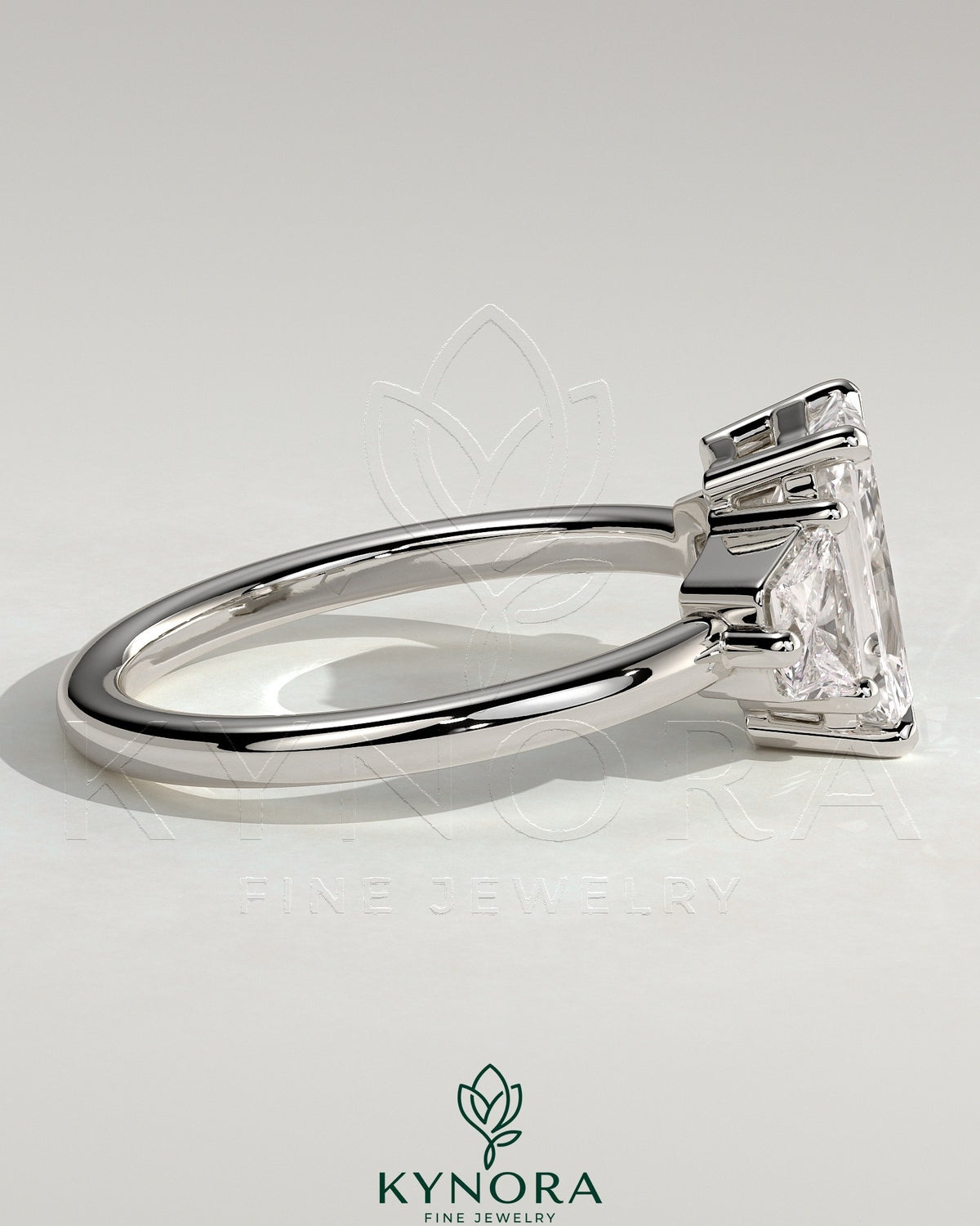 Kynora CJ 2ct radiant claw trilogy engagement ring with trapezoid side stones and low setting, showcasing elegant diamond craftsmanship.