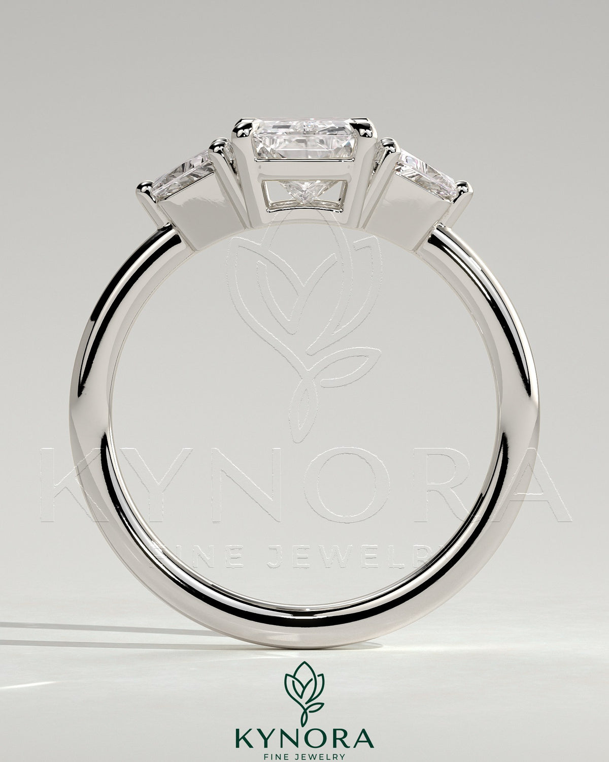 Kynora CJ 2ct radiant claw trilogy engagement ring with trapezoid side stones and low setting, elegant three-stone design.