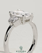Kynora CJ 2ct radiant claw trilogy engagement ring with trapezoid side stones and low setting, showcasing elegant diamond craftsmanship.