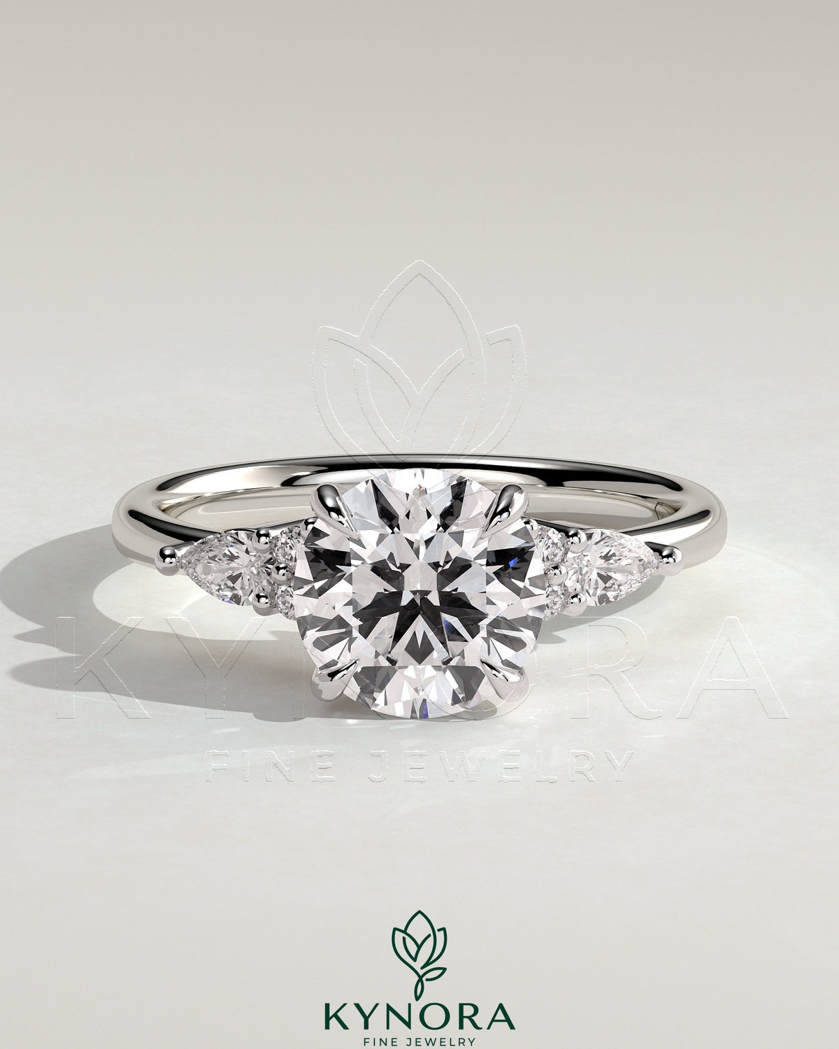 Kynora CJ 2ct round claw solitaire engagement ring with pear-shaped accents and round shoulder stones, three stone design. Main image