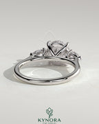 Kynora CJ 2ct round claw trilogy engagement ring with pear side stones and cathedral setting, showcasing elegant jewelry craftsmanship.