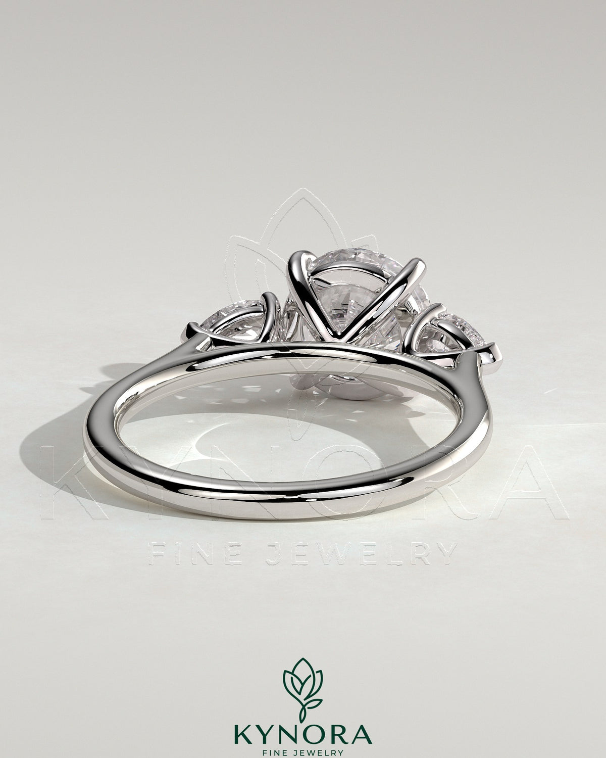Kynora CJ 2ct round claw trilogy engagement ring with pear side stones and cathedral setting, showcasing elegant jewelry craftsmanship.