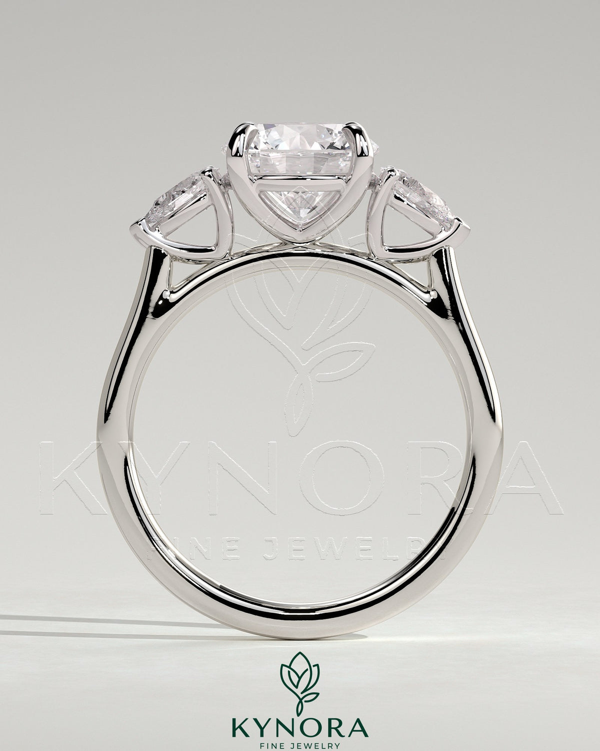 Kynora CJ 2ct round claw trilogy engagement ring with pear side stones and cathedral setting, showcasing elegant craftsmanship.