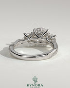 Kynora CJ 2ct round claw trilogy engagement ring with side stones, twisted pave band, and trellis gallery design.