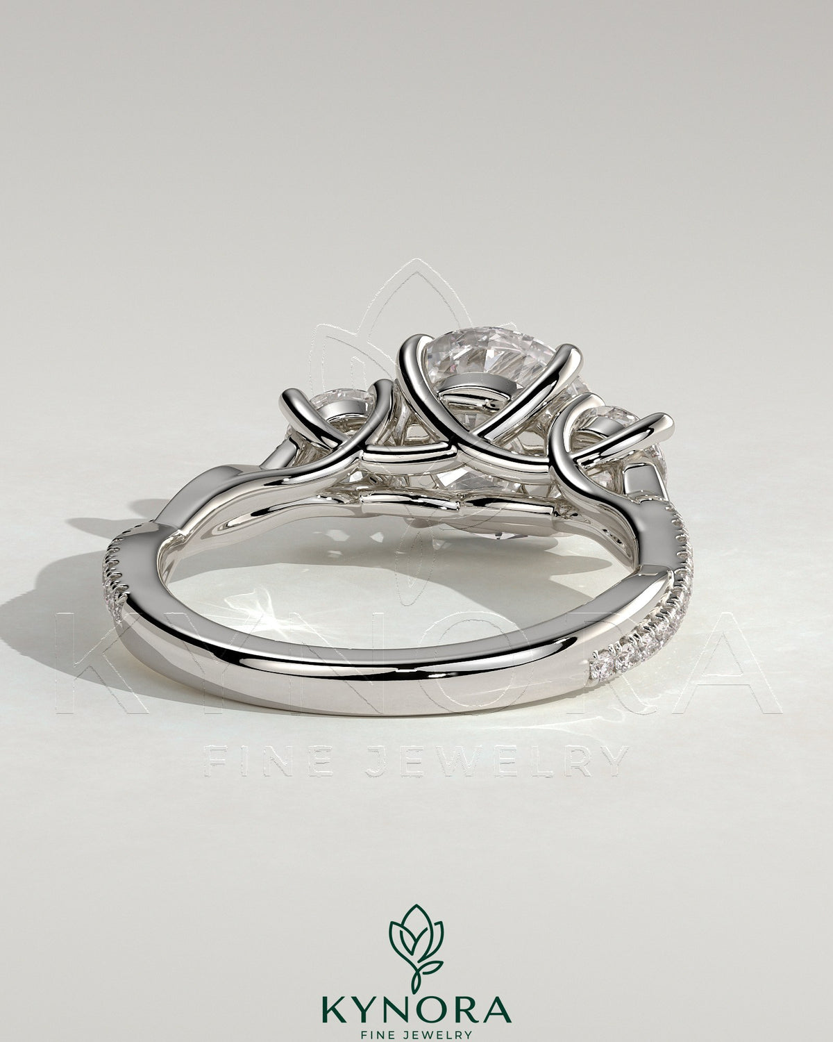 Kynora CJ 2ct round claw trilogy engagement ring with side stones, twisted pave band, and trellis gallery design.