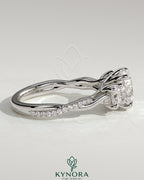 Kynora CJ three-stone engagement ring with 2ct round central stone, side stones, twisted pave band, and trellis gallery design.