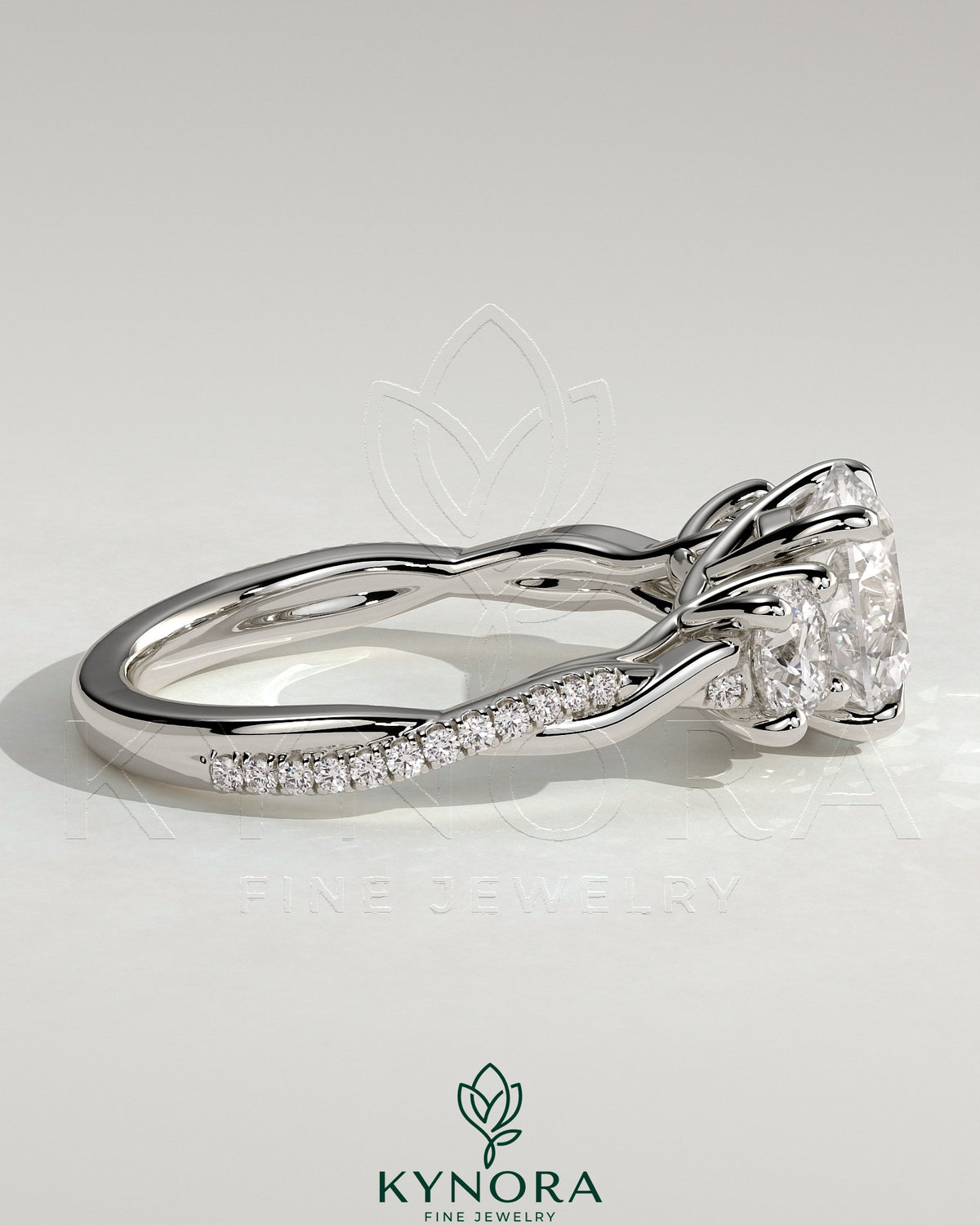 Kynora CJ three-stone engagement ring with 2ct round central stone, side stones, twisted pave band, and trellis gallery design.