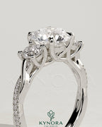 Kynora CJ three stone engagement ring with 2ct round claw trilogy center and side stones, twisted pave band and trellis gallery.