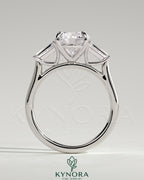 Kynora CJ 2ct round claw trilogy engagement ring with tapered baguette side stones in a cathedral setting.