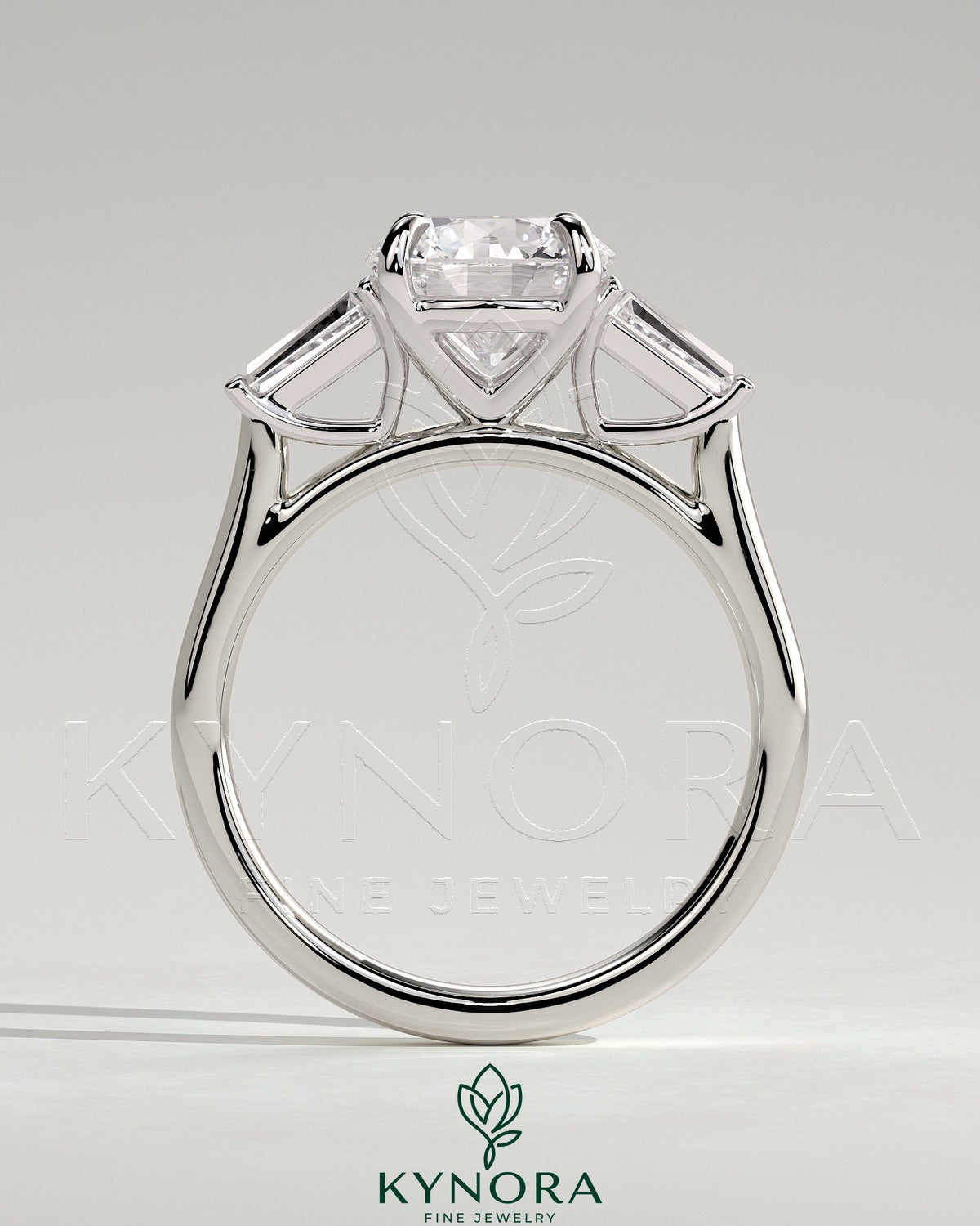 Kynora CJ 2ct round claw trilogy engagement ring with tapered baguette side stones in a cathedral setting.