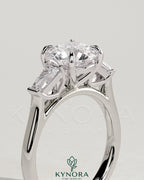 Kynora CJ 2ct round diamond trilogy engagement ring with tapered baguette side stones and cathedral setting.