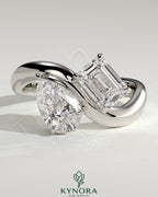 Kynora CJ Claw Toi et Moi engagement ring with wave band featuring two gemstones and intricate band design.