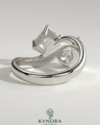 Kynora CJ Claw Toi et Moi engagement ring with wave band, featuring two intertwined gemstones in a delicate gold setting.