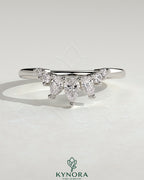 Kynora CJ accent stone wedding band with curved design, showcasing smooth metal band and sparkling stone accents on a white background.