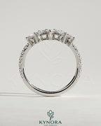 Kynora CJ wedding band featuring accent stones and a curved pave design, showcasing elegant jewelry craftsmanship.