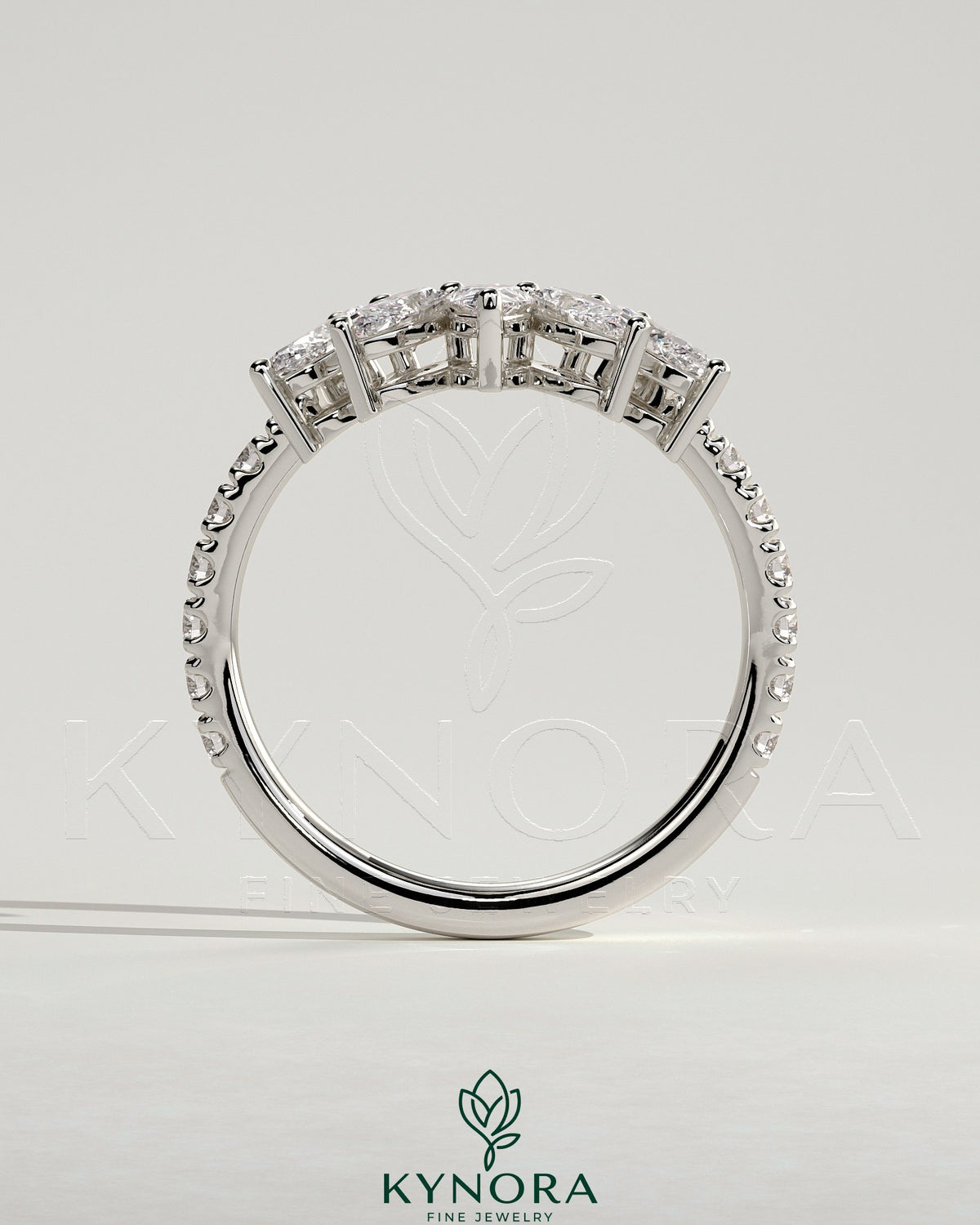 Kynora CJ wedding band featuring accent stones and a curved pave design, showcasing elegant jewelry craftsmanship.