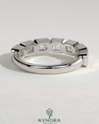 East West Emerald Bezel Set Wedding Ring by Kynora CJ, showcasing a sleek band with an emerald gemstone in a modern east-west setting.