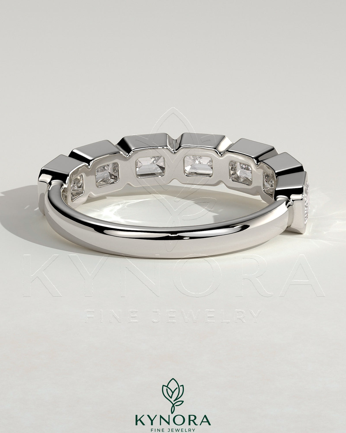 East West Emerald Bezel Set Wedding Ring by Kynora CJ, showcasing a sleek band with an emerald gemstone in a modern east-west setting.