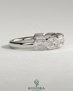 East West Emerald bezel set wedding ring by Kynora CJ, showcasing a green emerald gemstone on a sleek gold band.
