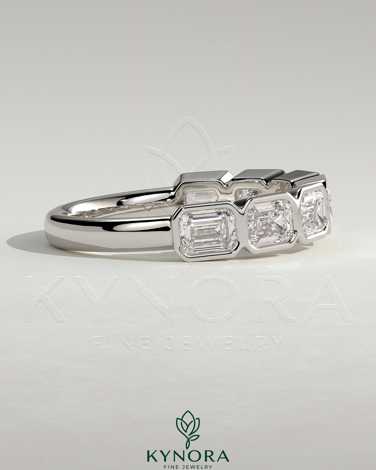 East West Emerald bezel set wedding ring by Kynora CJ, showcasing a green emerald gemstone on a sleek gold band.