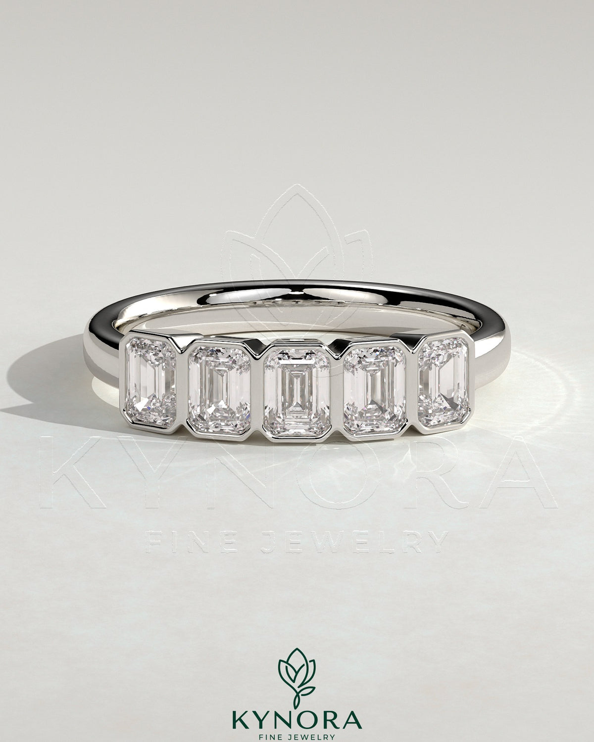 Emerald bezel set wedding ring by Kynora CJ with a sleek gold band and a central green emerald gemstone. Imagen principal del producto