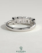 Emerald bezel set wedding ring by Kynora CJ featuring a central emerald gemstone in a sleek band design.