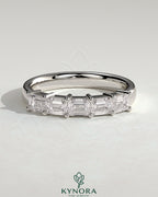 Kynora CJ emerald east-west wedding band with closed basket setting and accent stones, crafted for elegant wedding jewelry.