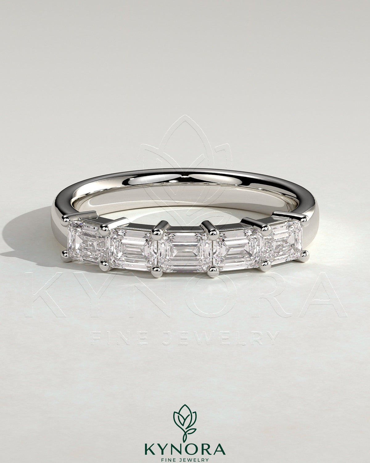 Kynora CJ emerald east-west wedding band with closed basket setting and accent stones, crafted for elegant wedding jewelry.