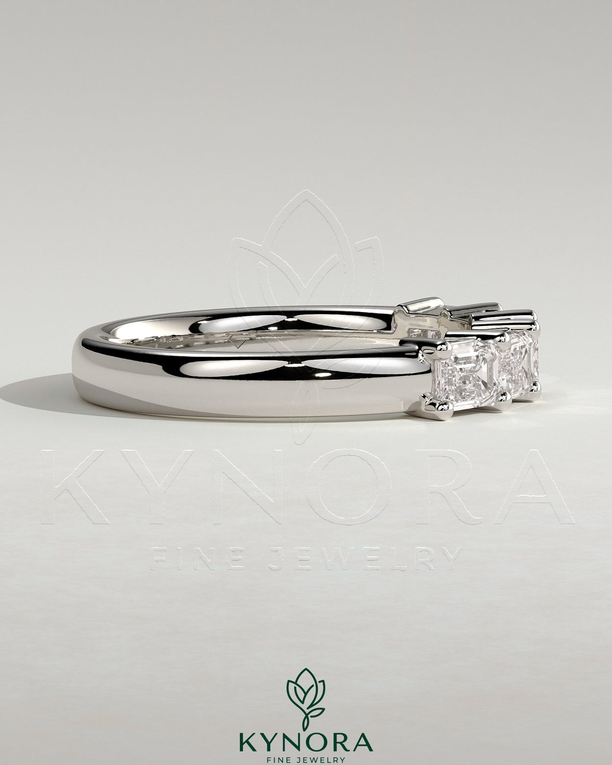 Kynora CJ Emerald East West accent wedding band with closed basket setting, featuring emerald stones on a sleek gold ring.