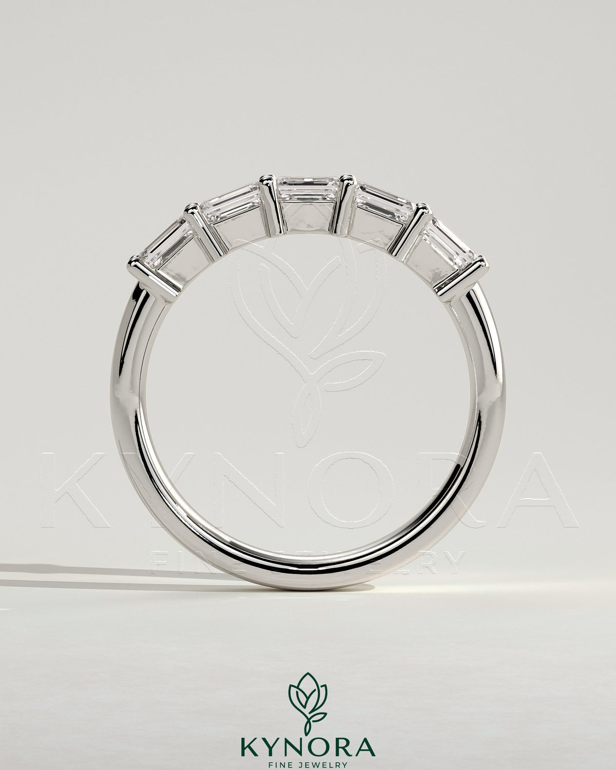 Kynora CJ emerald east-west accent wedding band with closed basket setting, featuring vibrant green emeralds and elegant gold band.