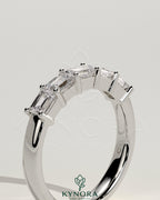 Kynora CJ emerald east-west wedding band with closed basket setting, featuring a vibrant green emerald stone and sleek gold band