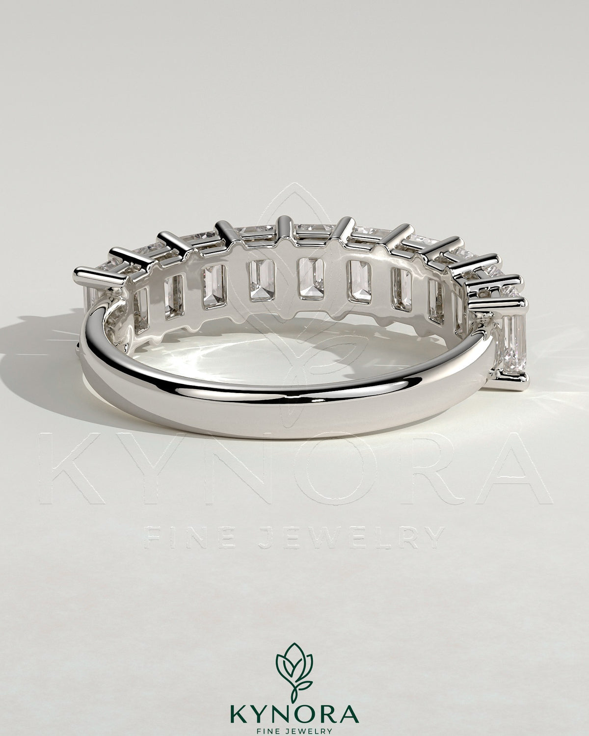 Emerald eternity band wedding ring by Kynora CJ featuring a continuous row of emerald gemstones on a sleek gold band.