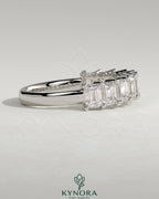 Emerald eternity band wedding ring by Kynora CJ featuring a continuous row of emerald gemstones in a sleek gold setting.